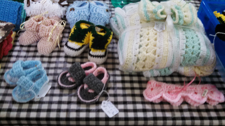 A variety of crocheted baby clothes.
